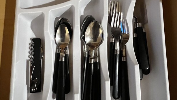 A white tray with compartments containing a knife, spoon, fork, and a bottle opener. - Canyon Plaza Premier Studios and Apts (Grand Canyon)