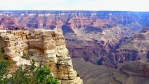 A panoramic view of a canyon with a viewing platform and visitors. - Canyon Plaza Premier Studios and Apts (Grand Canyon)