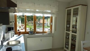 A kitchen with a window, a radiator, and a cabinet. - Ferienwohnung Fantaisie (Eckersdorf)