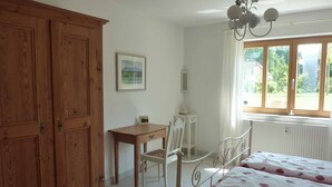 A bedroom with a bed, a desk, and a wardrobe. - Ferienwohnung Fantaisie (Eckersdorf)