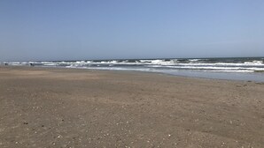 A beach with a clear sky and waves. - Nice apartment with golf course view in prestigious Brunswick Golf. Fits 4.  (Calabash)