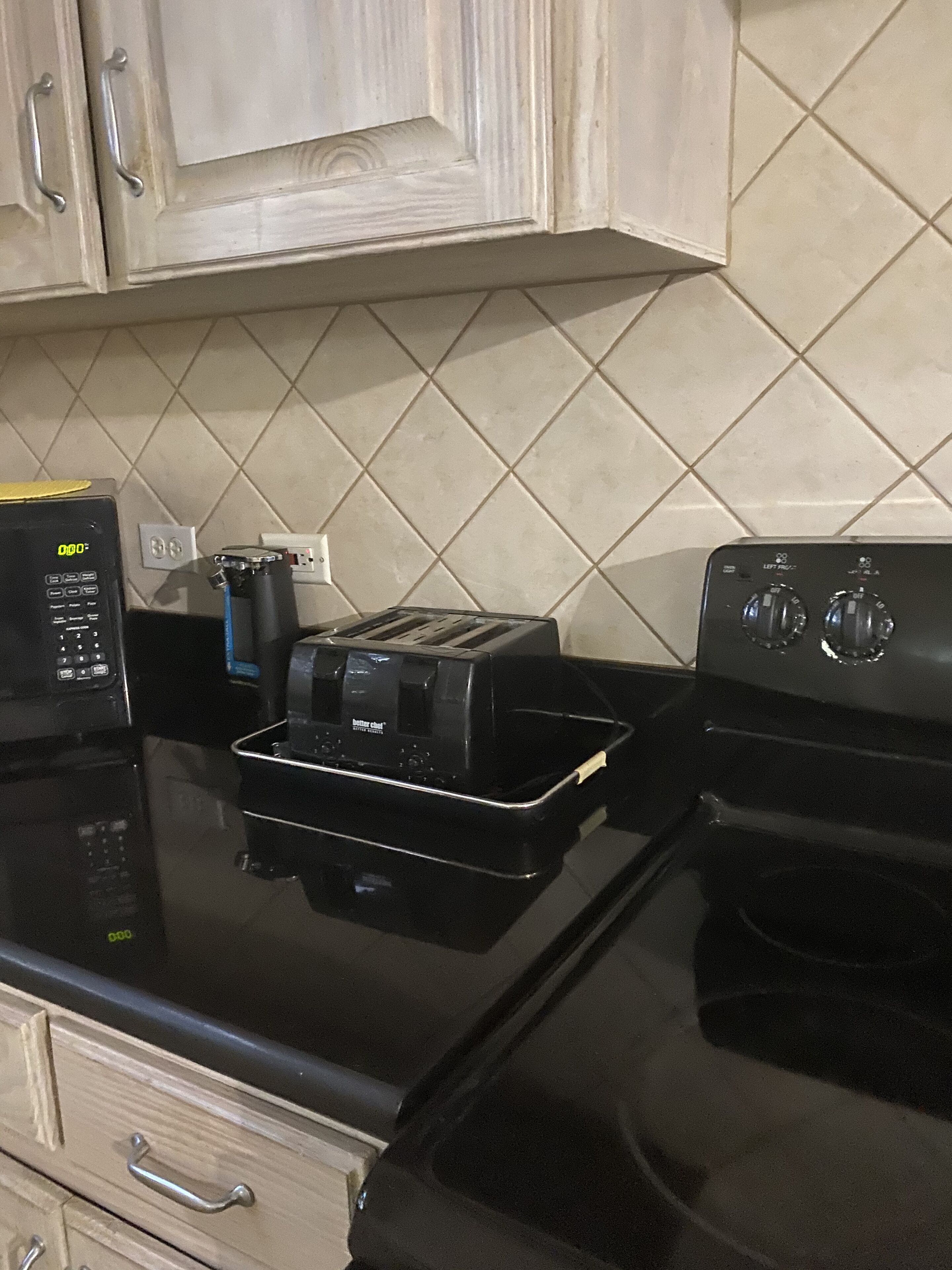 Une cuisine avec un four noir, un grille-pain et une machine à café posés sur le plan de travail.