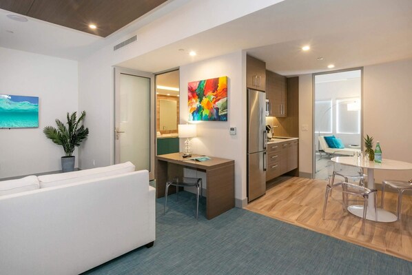 Eine moderne Wohnung mit Wohnzimmer, einer kleinen Küche und einem Essbereich.