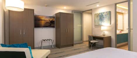 A modern hotel room with a bed, desk, and wardrobe.