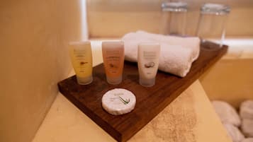 A wooden tray with four bottles of Regina spa therapy products and a round container with a green leaf design.