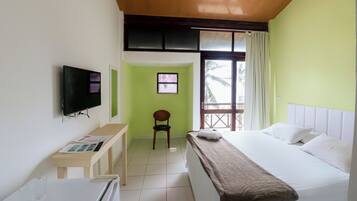 Ein Hotelzimmer mit Bett, Schreibtisch, Stuhl, Fernseher und Fenster.