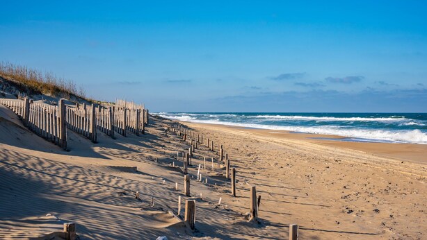 A sandy beach with wooden groynes and dunes. - First Floor, directly on the Ocean & Well Stocked Condo! Listen to Waves Crash! (Nags Head)