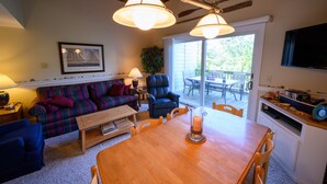 A cozy living room with a sofa, a chair, a wooden table, and a TV mounted on the wall. - Ocean Block. Steps from the beach! (Bethany Beach)
