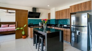 Een moderne keuken met een centraal eiland, roestvrijstalen apparatuur en houten keukenkastjes.