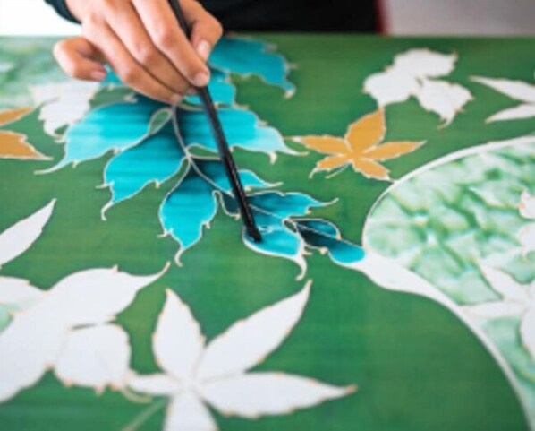 A hand holding a pen over a map with leaf patterns.