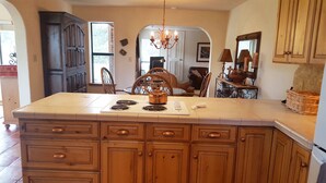 Una cocina con una isla grande, armarios de madera y un candelabro.