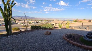 Un jardín ajardinado con un sendero de grava, cactus y una pequeña fuente.