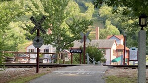 A railway crossing with a sign for Whistle Stop and Attitash. - Attitash Mountain Resort Condo- 3 Floors, Sleeps 12- Story Land, Ski, Shop, Golf (Bartlett)