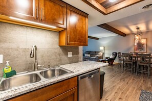 A kitchen with granite countertops, stainless steel appliances, wooden cabinets, and a dishwasher. - Rustic, Cozy 2 Bed/1 Bath, In-Unit Laundry, Parking + 6 blocks from Mayo! (Rochester)