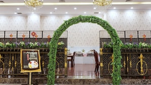 A reception area with a green archway, a signboard, and a decorative wall with hanging ornaments. - Weiluola Hotel Xiamen (Xiamen)
