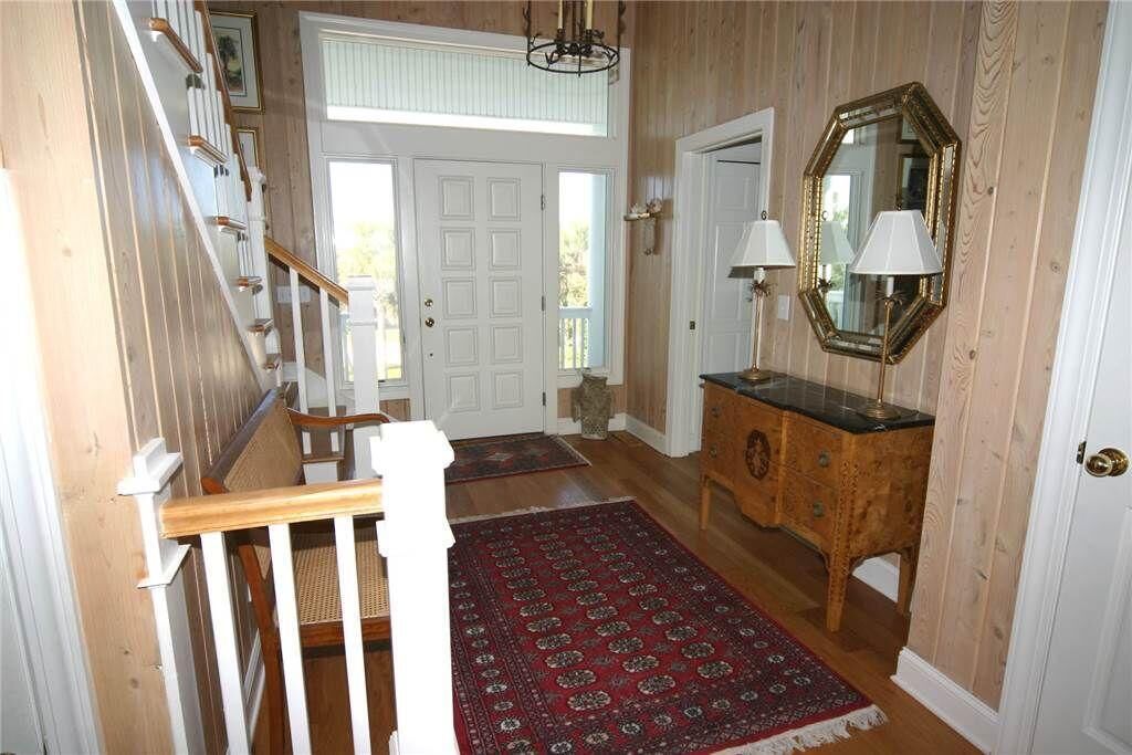 A wooden staircase with white railings leading to a door.