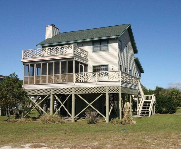 A two-story house with a balcony and a covered porch.