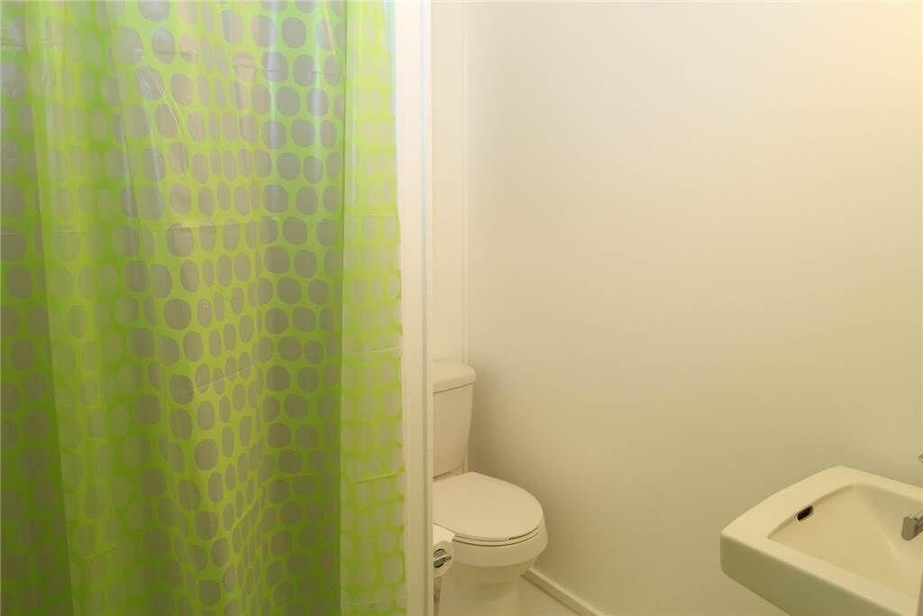A bathroom with a toilet, a sink, and a shower curtain with a geometric pattern.