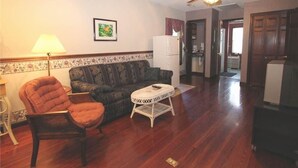 A living room with a sofa, armchair, and a small round table.