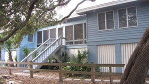 A two-story house with a wooden staircase leading to the upper floor. - Seaczar's Retreat (Edisto Island)