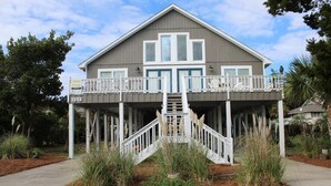 A two-story house with a balcony, a staircase leading to the upper level, and a number sign '1303' indicating the address.