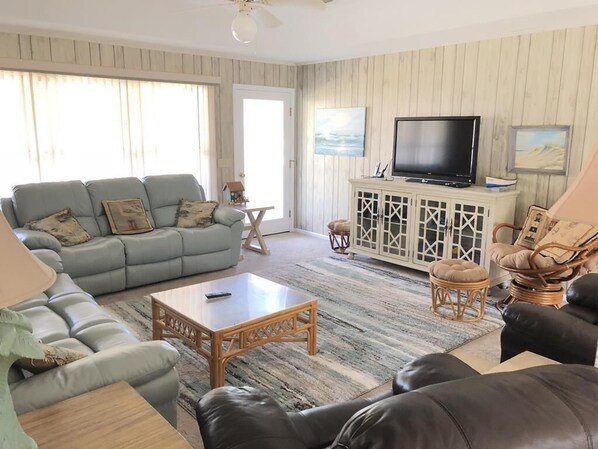 A living room with a sofa, armchairs, a coffee table, a TV, and a cabinet. - Jumangi (Edisto Island)