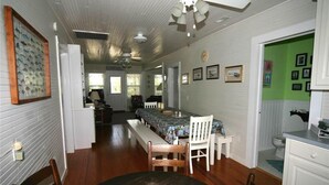 A spacious kitchen with a dining area, wooden flooring, and a ceiling fan. - Just Sew (Edisto Island)