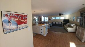 A spacious living area with a kitchen, a dining area, and a large window. - Rooney Bin (Edisto Island)