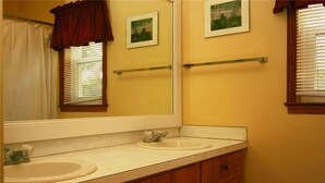A bathroom with two sinks, a mirror, and a towel rack.