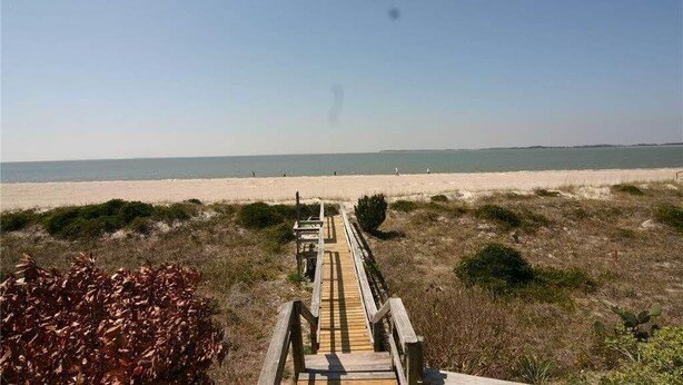 A wooden boardwalk leading to a beach with a clear sky. - Sound Pleasures (Edisto Island)