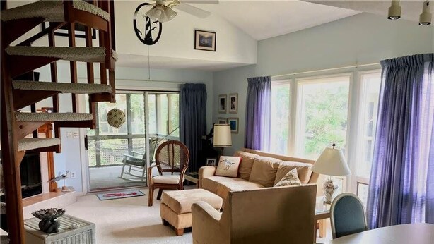 A cozy living room with a sofa, armchair, and a dining table. - Summerwind 782 (Edisto Island)