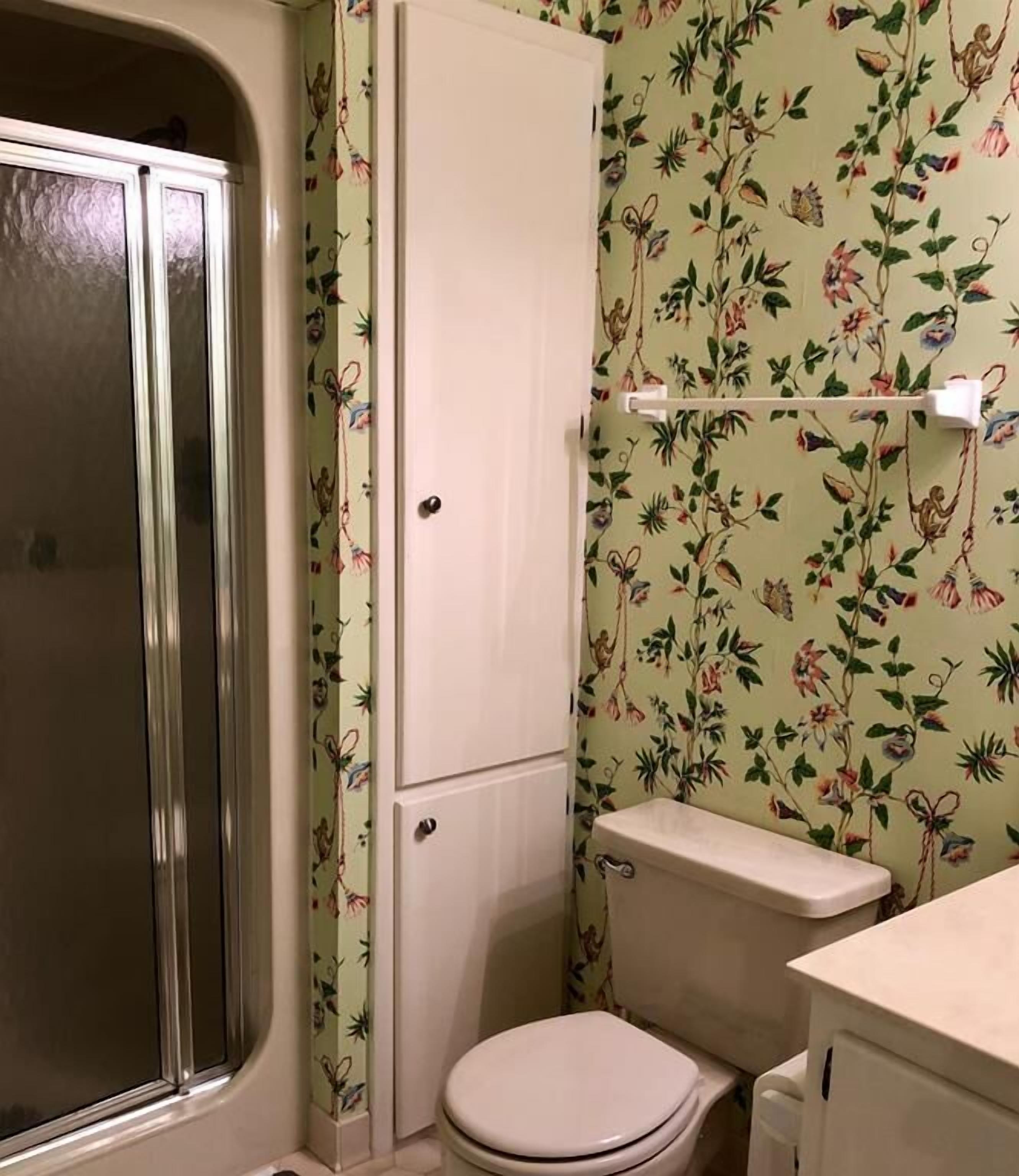 A bathroom with a shower, toilet, and sink.
