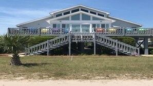 A two-story building with a central staircase and a covered walkway. - A Shore Investment (Edisto Island)