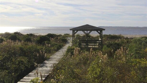 A wooden boardwalk leading to a gazebo by the beach. - Anchor inn (Edisto Island)