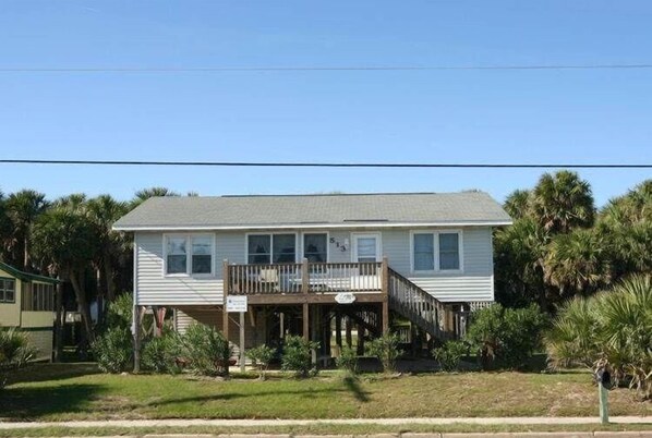 A two-story house with a front porch and a small deck.