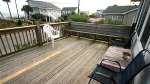 A wooden deck with a bench and chairs, overlooking a coastal area with houses. - Dowry (Edisto Island)