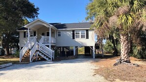 A two-story house with a front porch and a staircase leading to the entrance. - Dreamcatcher (Edisto Island)