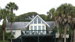 A two-story house with a balcony and a covered porch. - Green Parrot (Edisto Island)