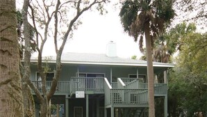 A two-story building with a balcony and a staircase leading to the upper floor. - Miss Irene (Edisto Island)