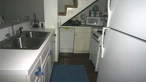 A compact kitchen with a double sink, a microwave, and a refrigerator.