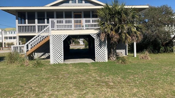 A two-story house with a balcony, a covered porch, and a staircase leading to the upper level. - Shark's Tooth (Edisto Island)
