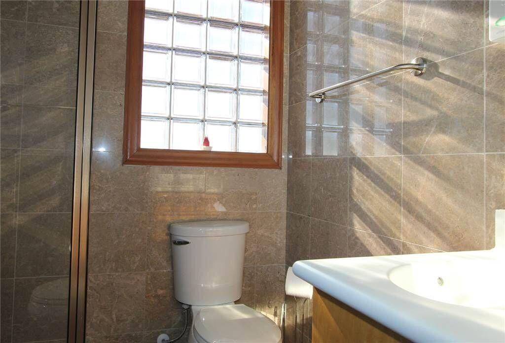 A bathroom with a shower, a toilet, and a sink.