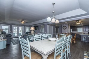 A spacious living room with a dining area, a kitchen, and a balcony. - Sutton House (Edisto Island)