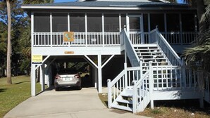 A two-story building with a covered parking area and a staircase leading to the upper level. - Swamp Fox (Edisto Island)