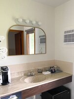 Bañera con ducha, artículos de tocador de diseñador, secador de pelo