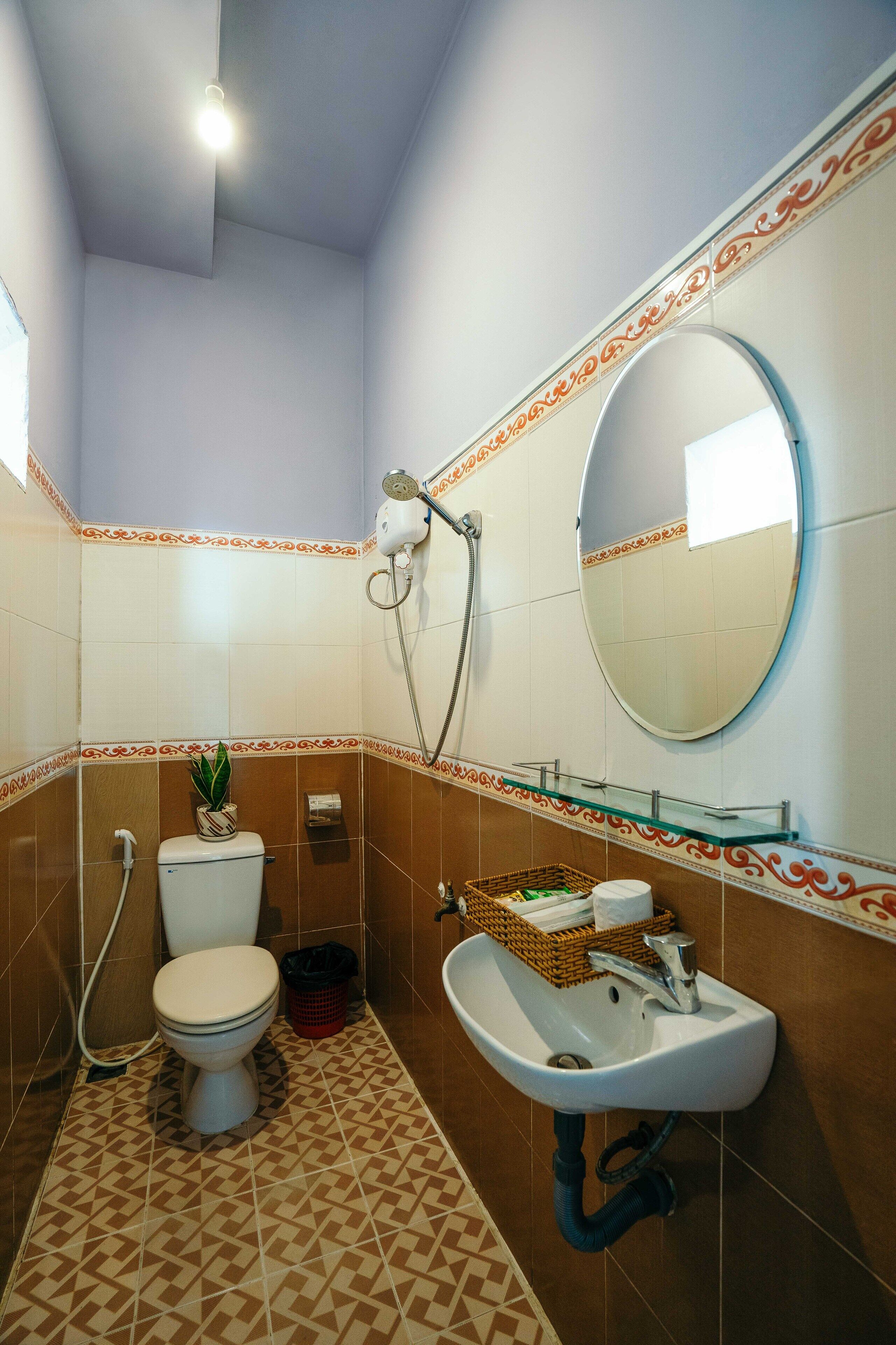 A bathroom with a toilet, sink, and shower.