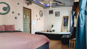 Une chambre d’hôtel avec un lit, un bureau, une chaise et un miroir.