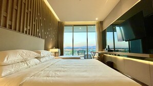 Een moderne hotelkamer met een groot bed, een bureau en een televisie.