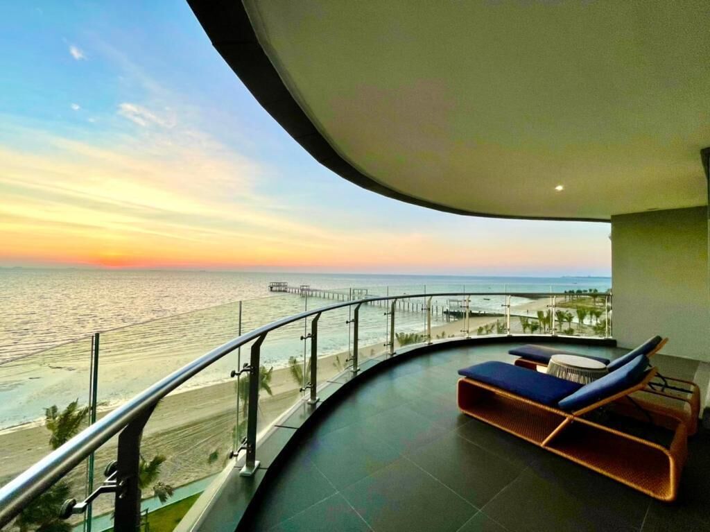 A balcony with a view of the ocean and a sunset.