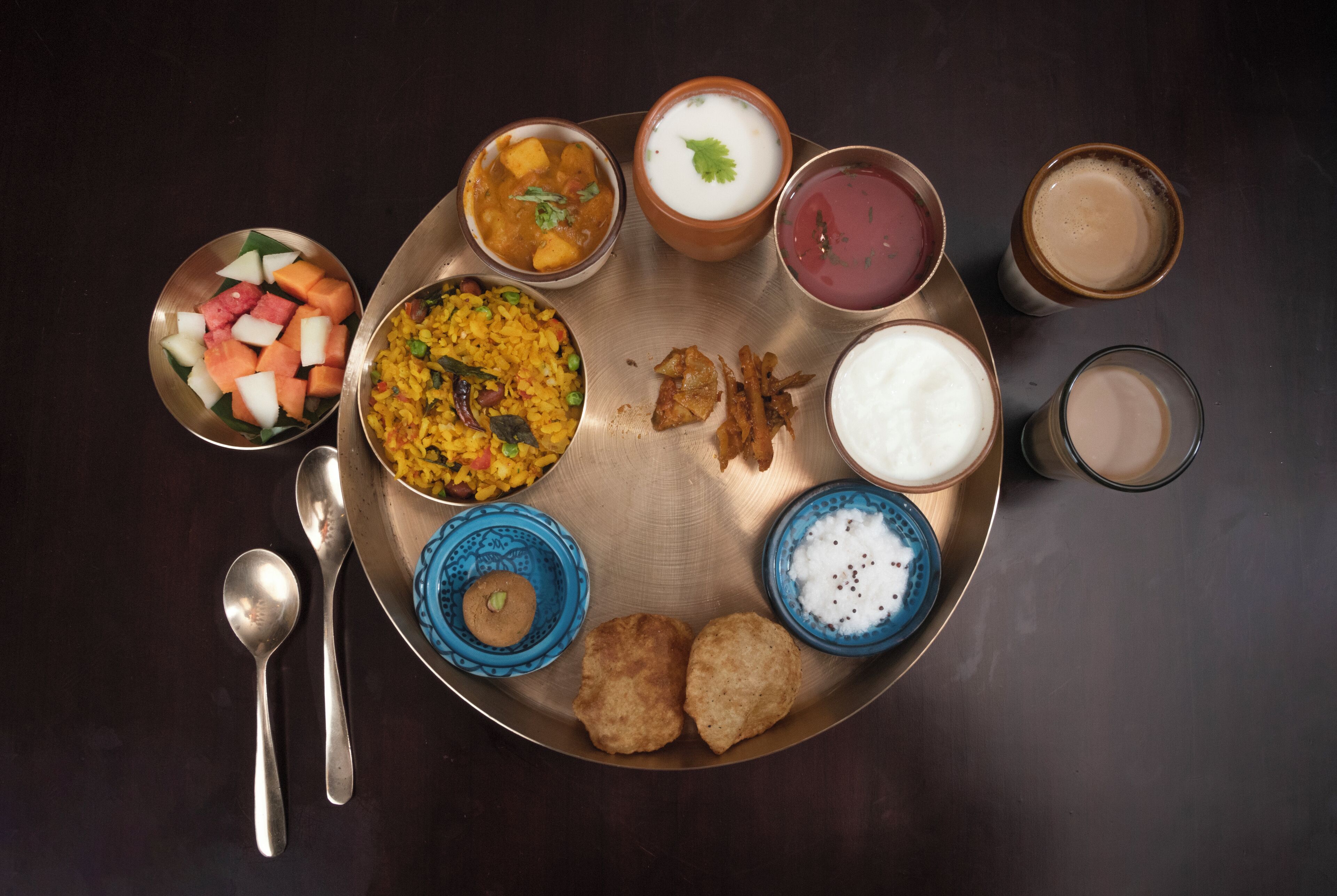 A meal with various dishes and drinks on a metal tray.